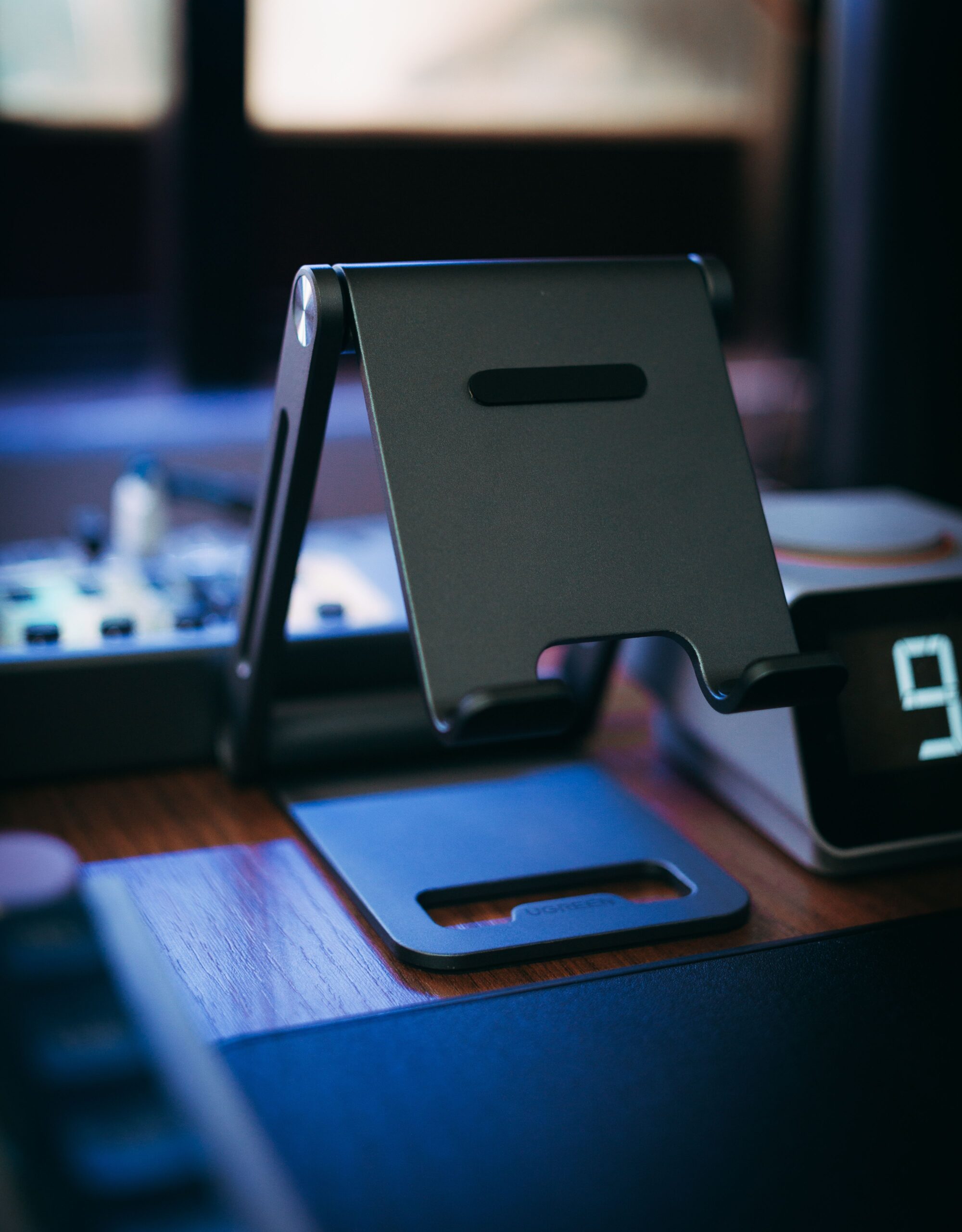 A sleek metal tablet stand on a wooden desk, perfect for tech setups.