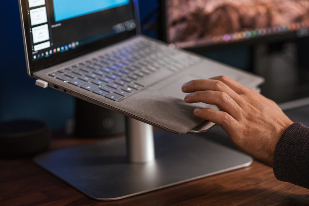 Laptop Stand Buying Guide: Best Ergonomic Risers Crop unrecognizable male browsing modern netbook and scrolling touchpad placed on stand on desk