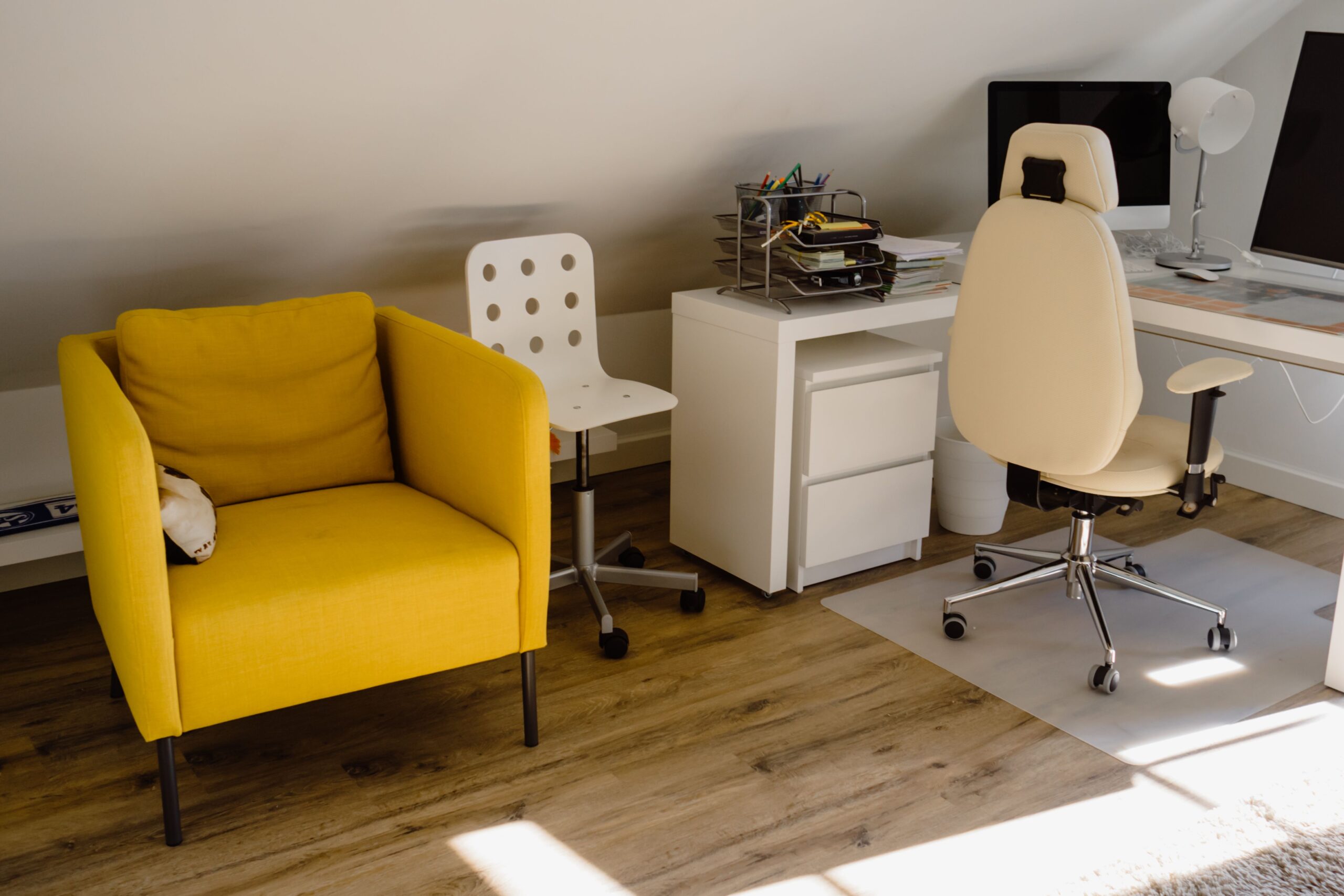 What We Review Bright home office with a yellow chair and organized desk setup.