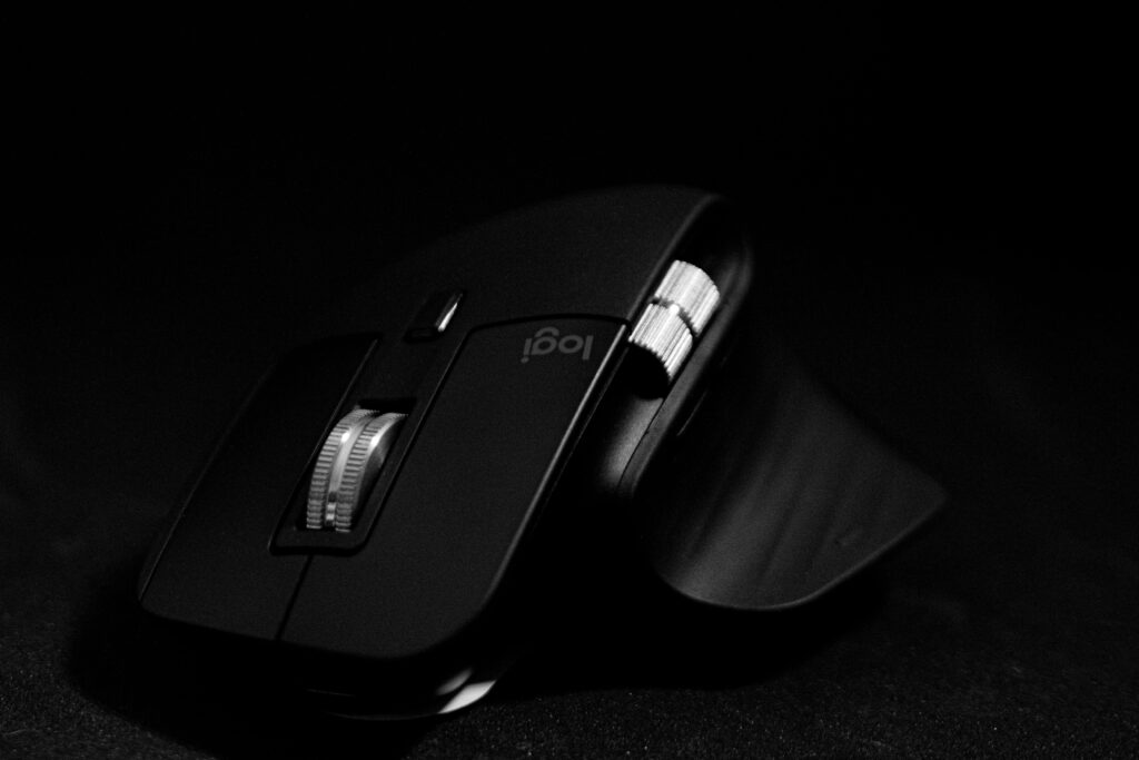 Close-up of a sleek black wireless computer mouse against a dark background, highlighting its design.