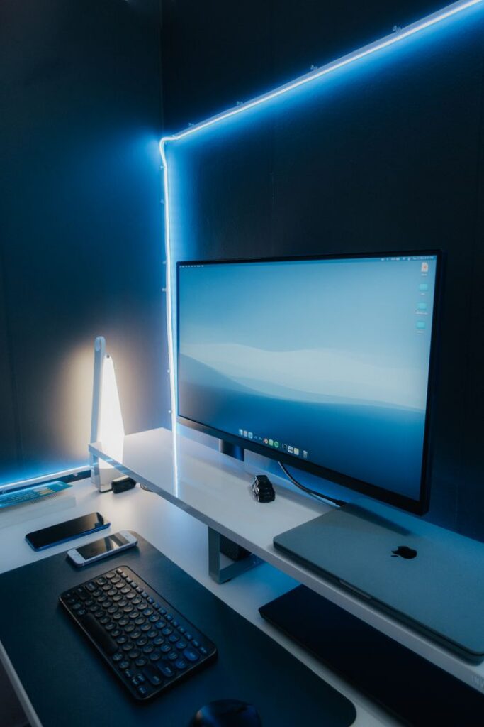How Far Should Your Monitor Really Be? A sleek and modern workspace setup featuring a desktop monitor, keyboard, and LED lighting.