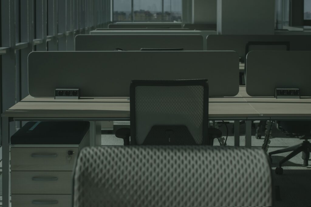 5 Signs Your Office Chair Is Causing You Back Pain A sleek modern office with multiple desks and chairs, showcasing an empty and orderly workspace.